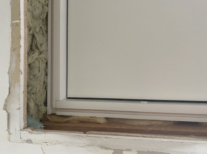Upp och ner-vänd bild av en fönsterinstallation med synlig isolering och ofärdiga väggkanter.