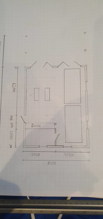 Handritad skiss av husplan med måttangivelser och markerad bänk.
