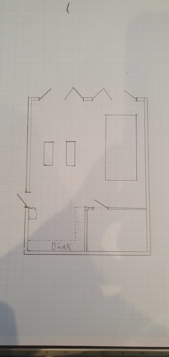 Handritad skiss av en husplan med markerade fönster, bank och dörrar på rutat papper.