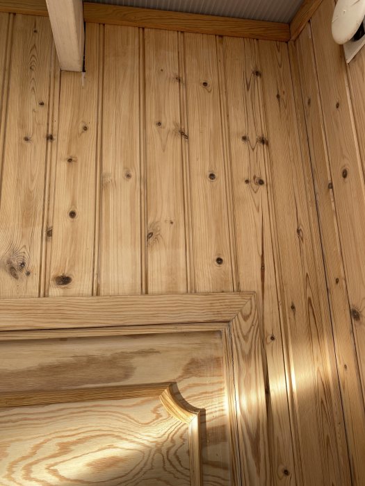 Ubehandlad träpanel i en inglasad altan som användare vill måla vit.