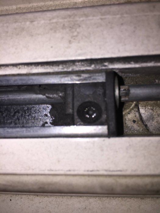 Närbild av en balkongdörrskruv med stjärnmönster, som kräver en stjärnskruvmejsel.