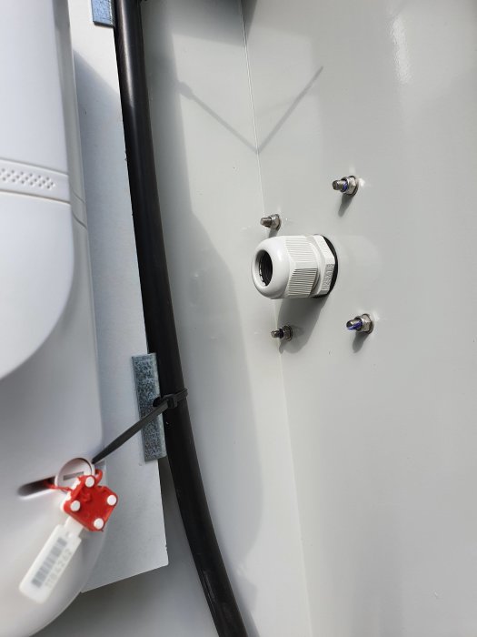 Elskåpsinstallation utomhus med vägggenomföring och kablar, ej färdigställt på grund av åska och regn.