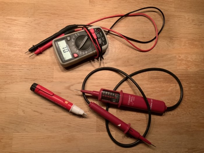 Kontaktlös spänningsdetektor, spänningsprovare och multimeter på trägolv.