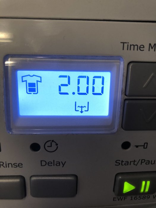 Display på tvättmaskin visar programtid på 2 timmar och symboler för tvätt och sköljning.