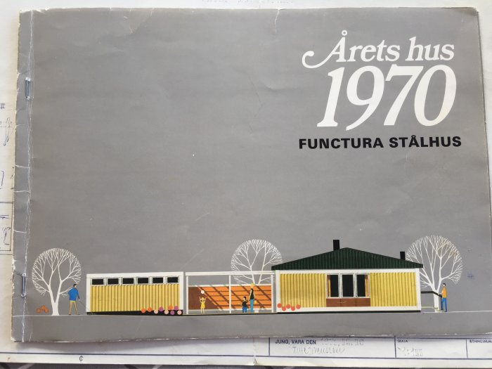 Broschyr från 1970 med titeln "Årets hus" och illustration av ett Funcura stålhus, omgiven av tecknade träd och figurer.