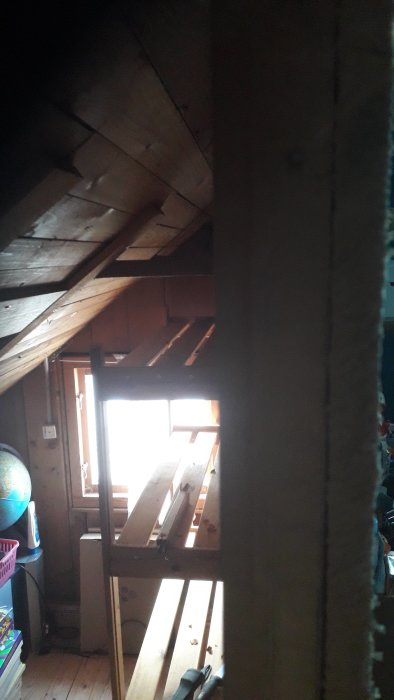 Inomhusvy av en potentiellt bärande vägg av stående spontade plank i ett hem under renovering.