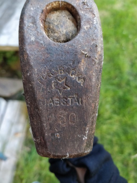 Närbild på ett hammarhuvud med texten 'JABSTÅL' och siffrorna '30', representerar testat arbete i en ässja.