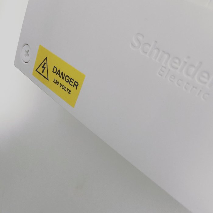 Varningsklistermärke på Schneider Electric-utrustning som anger 'FARA 230 VOLTS'.