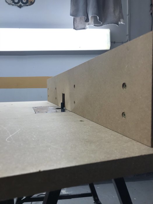 Nybyggt fräsbord i trä med synlig fräs och installationshål, innan slutlig montering och puts.