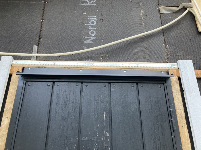 Nymålad svart panel med överbleck och skyddsräcke för att förhindra fåglar från att nista.