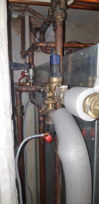 Rör och kopplingar på en IVT Greenline bergvärmepump och en strömnäspanna TS500 med synliga tryckmätare.
