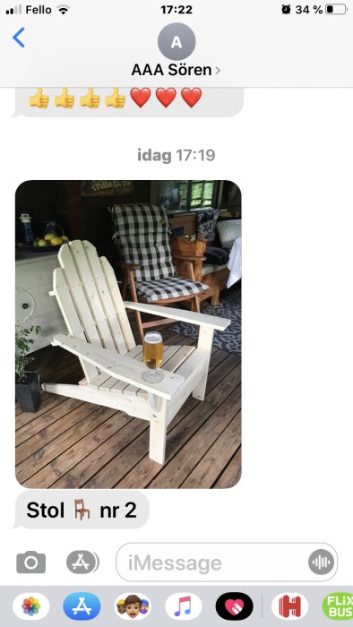 Ny vitmålad furudäcksstol på träveranda med ett glas öl på armstödet.