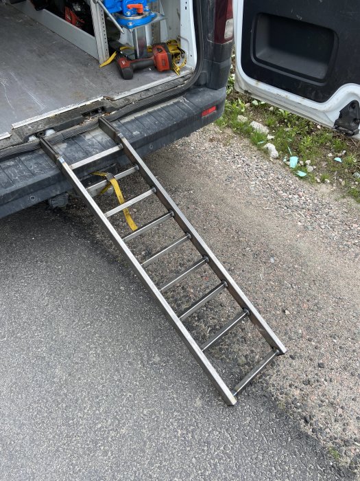 En hemmagjord metallramp för motorcyklar som är fästad vid bakdörren på en skåpbil.