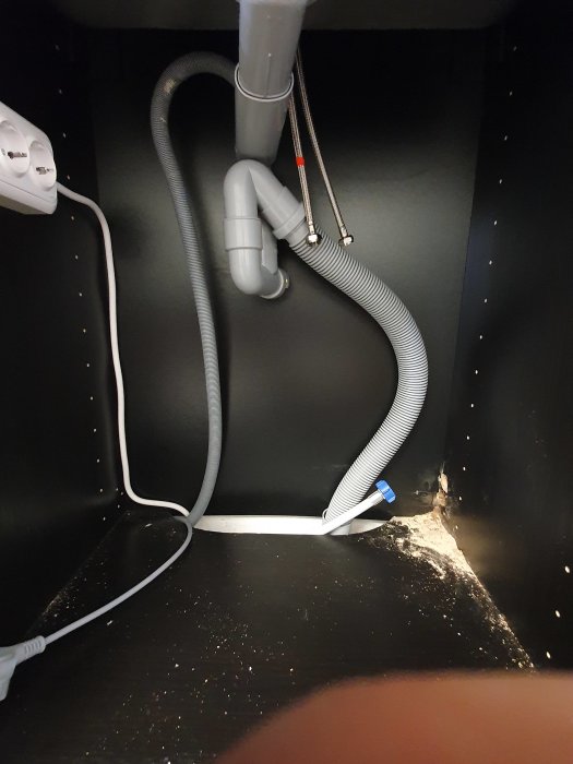 Installation av VVS i tvättstuga med synliga vattenrör, avloppsrör och anslutningar, samt uttag för tvättmaskin.
