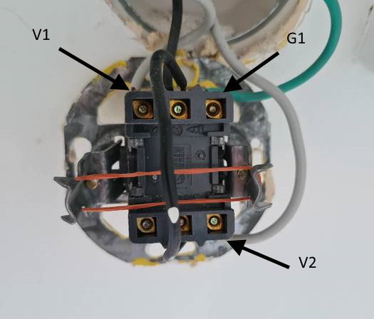 Eluttag med märkta kablar och brytare före korrigering av elinstallation.