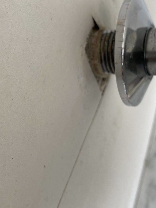 Rörände som sticker ut från en vägg med skruvbar platta, eventuell demontering för återanvändning.