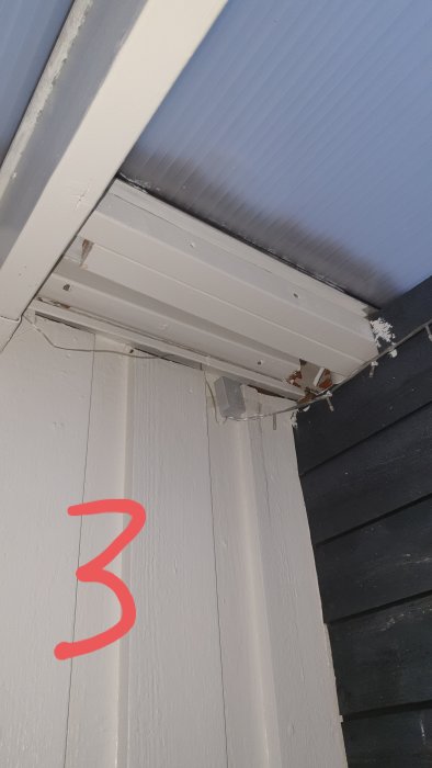 Takdel nära husvägg med tecken på läckage och skadade områden där tätning behövs.