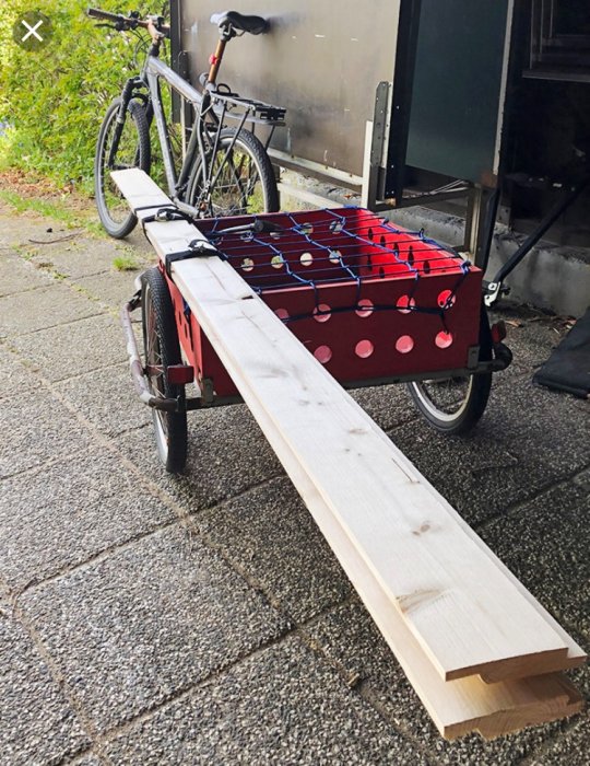 Omvandlad cykelvagn med plywood och limträ används som transportvagn för verktyg och varor.