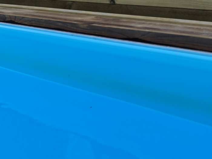 Nybyggd poolkant med en synlig rand längs poolens insida.