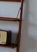 Trähylla med ett gammalt radiosystem och stödstång.