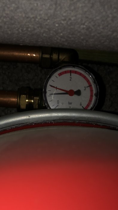 Tryckmätare på cirka 1.5 bar i ett värmesystem, fråga om rätt trycknivå för systemet.
