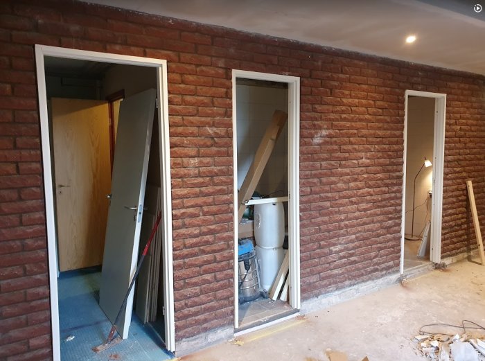 Renoveringsprojekt med nya dörrkarmar i tegelvägg och förberedelser för målning.