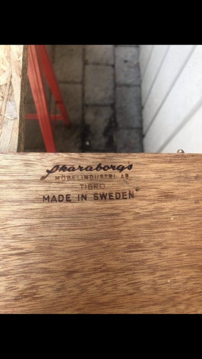 Träyta med stämpling "Skaraborgs Möbelindustri AB Tibro Made in Sweden".