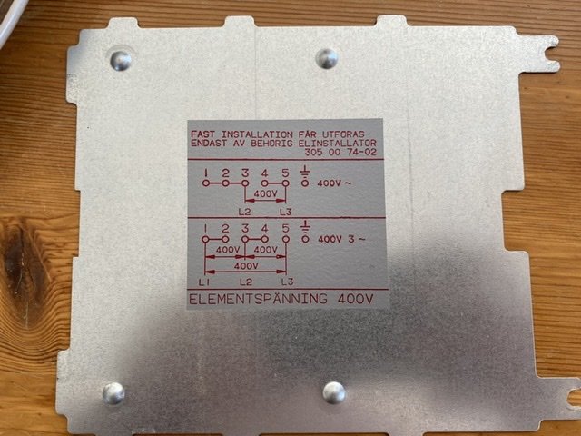 Kopplingsschema för spis med markeringar för 2-fas och 3-fas anslutning på en metallplatta.
