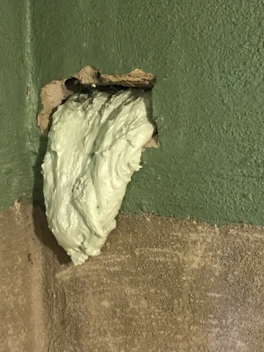 B-bruk applicerat på en skadad vägg med grönt ytskikt, där putsningsarbetet påbörjats men ännu inte är slutfört.