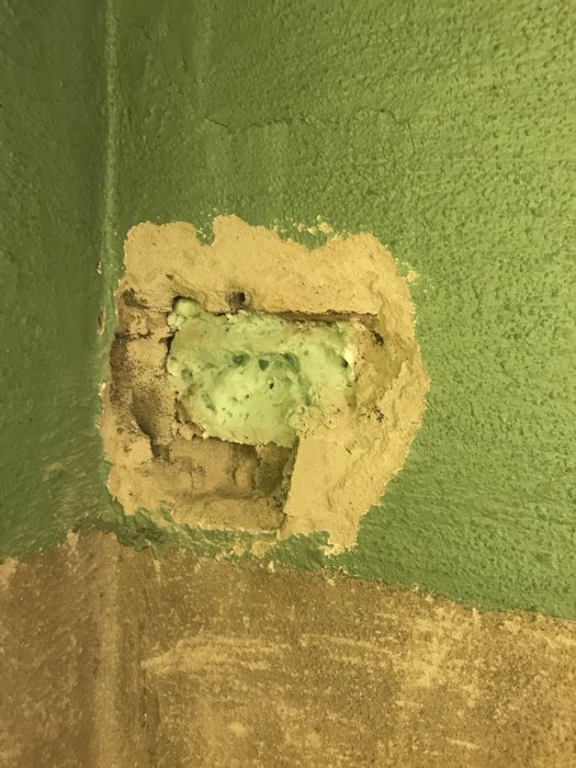 En vägg med grönt B-bruk på både in- och utsidan runt ett ojämnt mursprick.