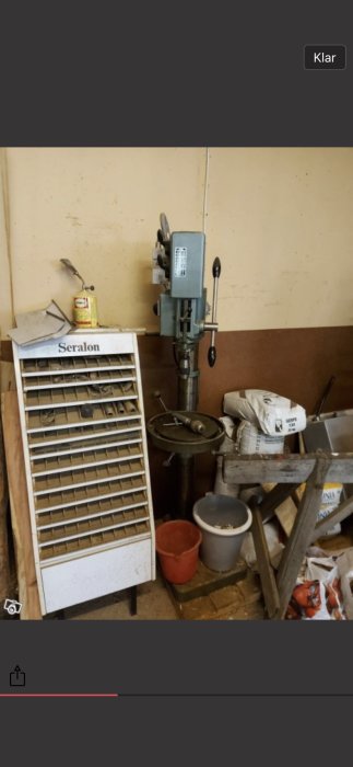 En Arboga G2508 pelarborrmaskin i ett verkstadsrum med verktygslåda och diverse arbetsmaterial.