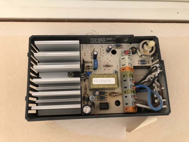 Uppslagen äldre analog termostat för FTX-system med kretskort och komponenter synliga.