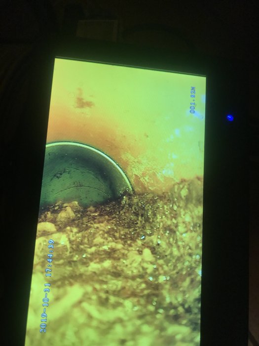 Inspektionsbild från en avloppsrörskamera som visar röret blockerat av gammalt flytspackel.