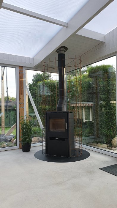 Armeringsjärn bockat runt en kamin för projektet, ommålad vit innertak och synliga trädetaljer.