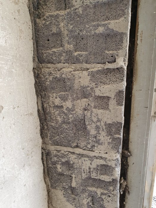 Vanhan muuratun talon kulma, jossa näkyy vaurioitunutta laastia ja ilmakuoppia kevytsoraharkoissa, sekä pehmeää saumaa.