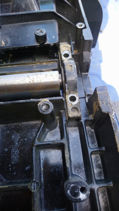 Aluminiumram med fasta lagerhållare och skruvar, samt synliga spår av slitage och användning.
