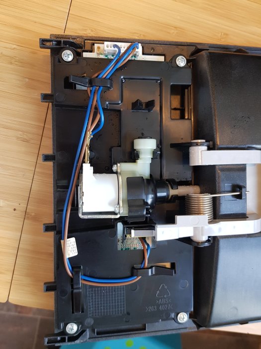 Öppen mekanism av en dubbelsidig dörrmodell med synliga elektriska ledningar och mekaniska delar.