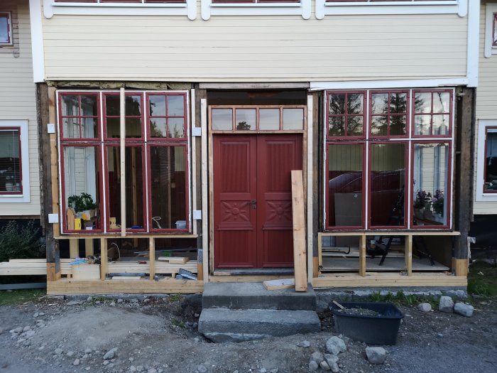 Renoveringsarbete på hus med utplacerad dörrkarm och fönsterpartier, några delar med rötskador.