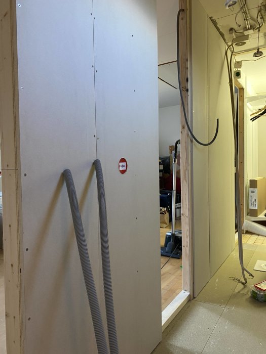 Enkel vägg med förberedda elinstallationer och synliga kabelskyddsrör.