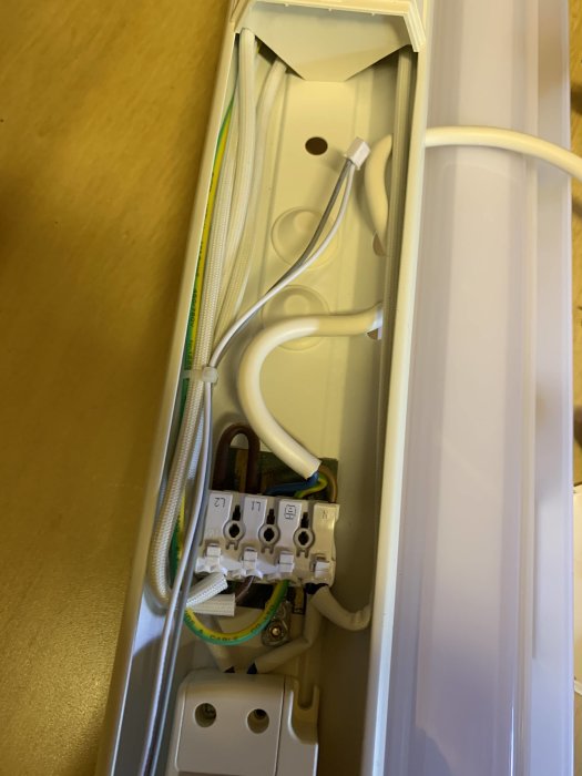 Elektrisk kabelkanal med tre hål och kablar anslutna till en kabelkopplingsplint.