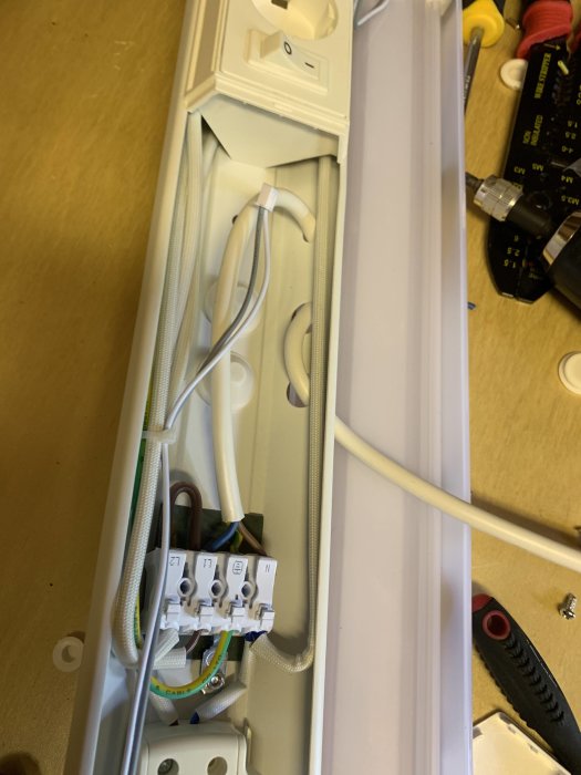Eluttag med kablar och avlastning genom hål i installationsskena.