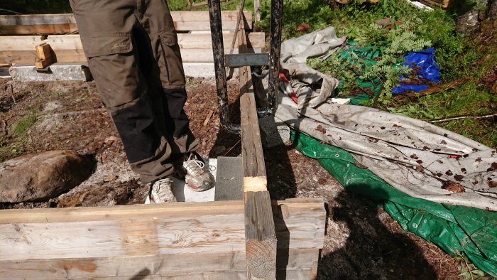 Rätning av vridd planka med improviserad rakningsanordning av plattjärn utomhus.