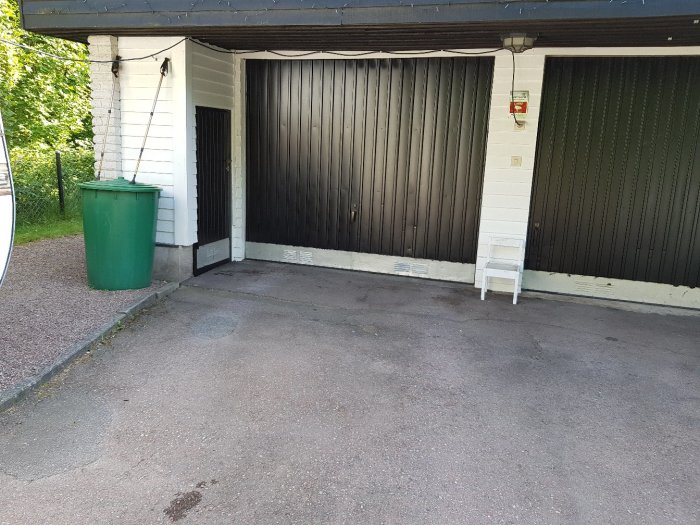 Garageport som hänger snett till höger och skaver mot karmen, med synlig ojämn kant längst ned.