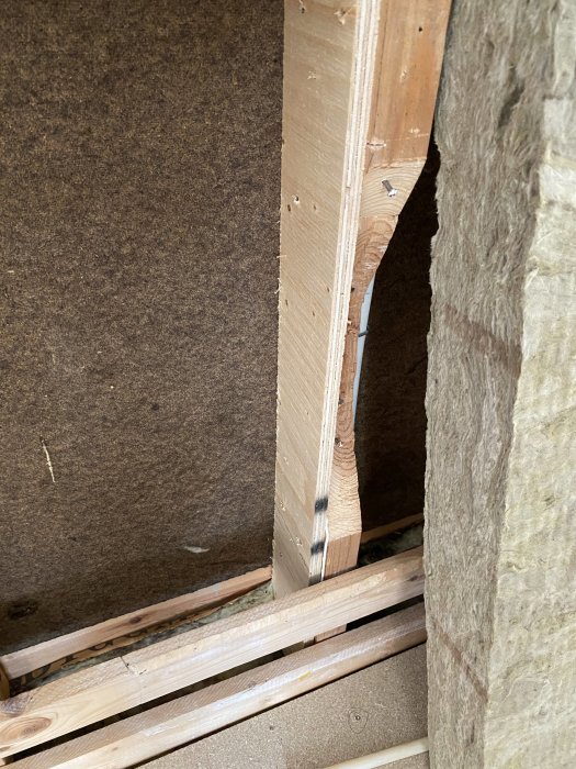 Förstärkt takstol med plywood och skruvar vid en byggrenovering.