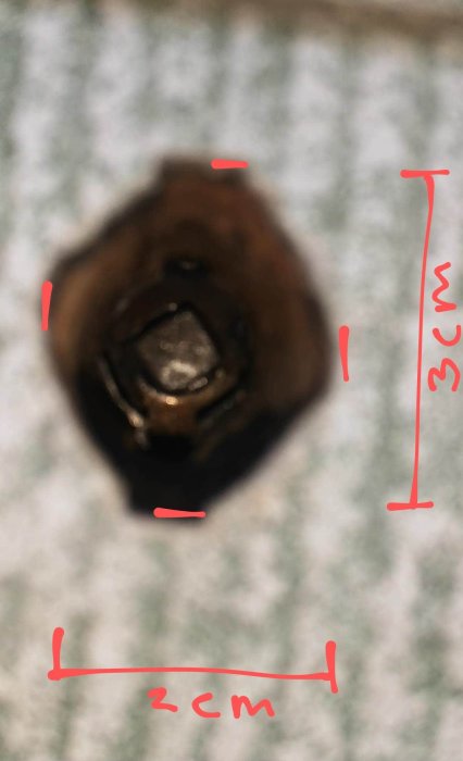 Närbild på en vindsluckas låsmekanism, markerad med röda linjer som visar en 8 cm fyrkant och 3 cm djup.