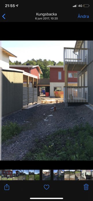 Nybyggt hus med en tom carport och en extern trätrappa till övervåningen, omarkerad tomt runtom.