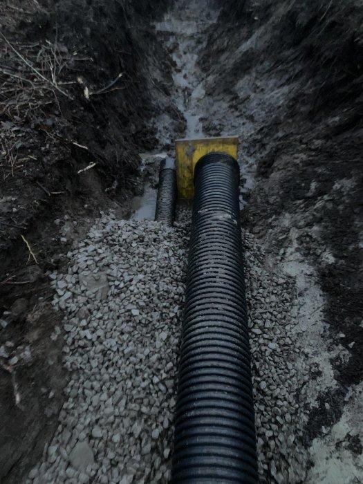 Grundarbete för garage med 300mm och 160mm rör i grusat dike på byggplatsen.