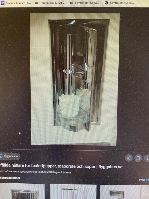 Infälld toalettborstehållare i genomskinlig behållare med vita borstar.