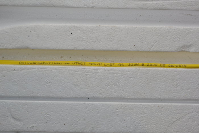 Extruderade skivor med en gul elkabel märkt med tekniska specifikationer och inköpskälla.