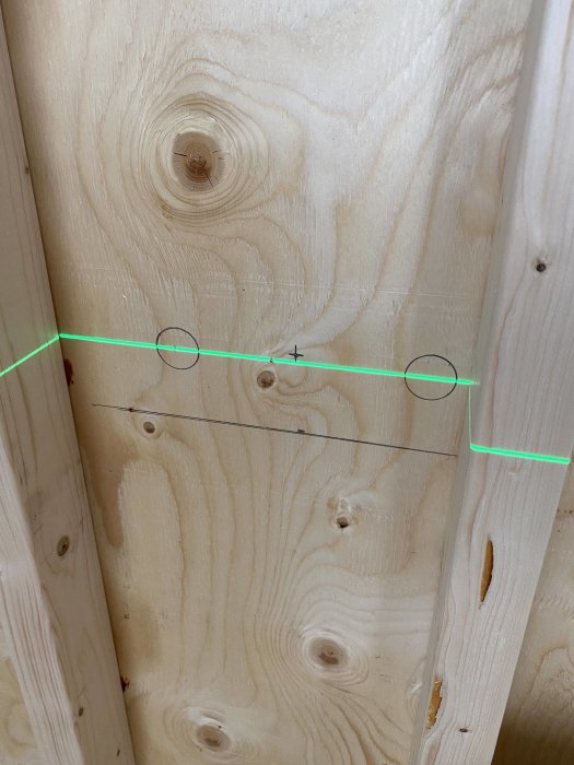 Träkonstruktion med uppritade hålpositioner för kapning, synlig bockfixtur och mätmarkering.